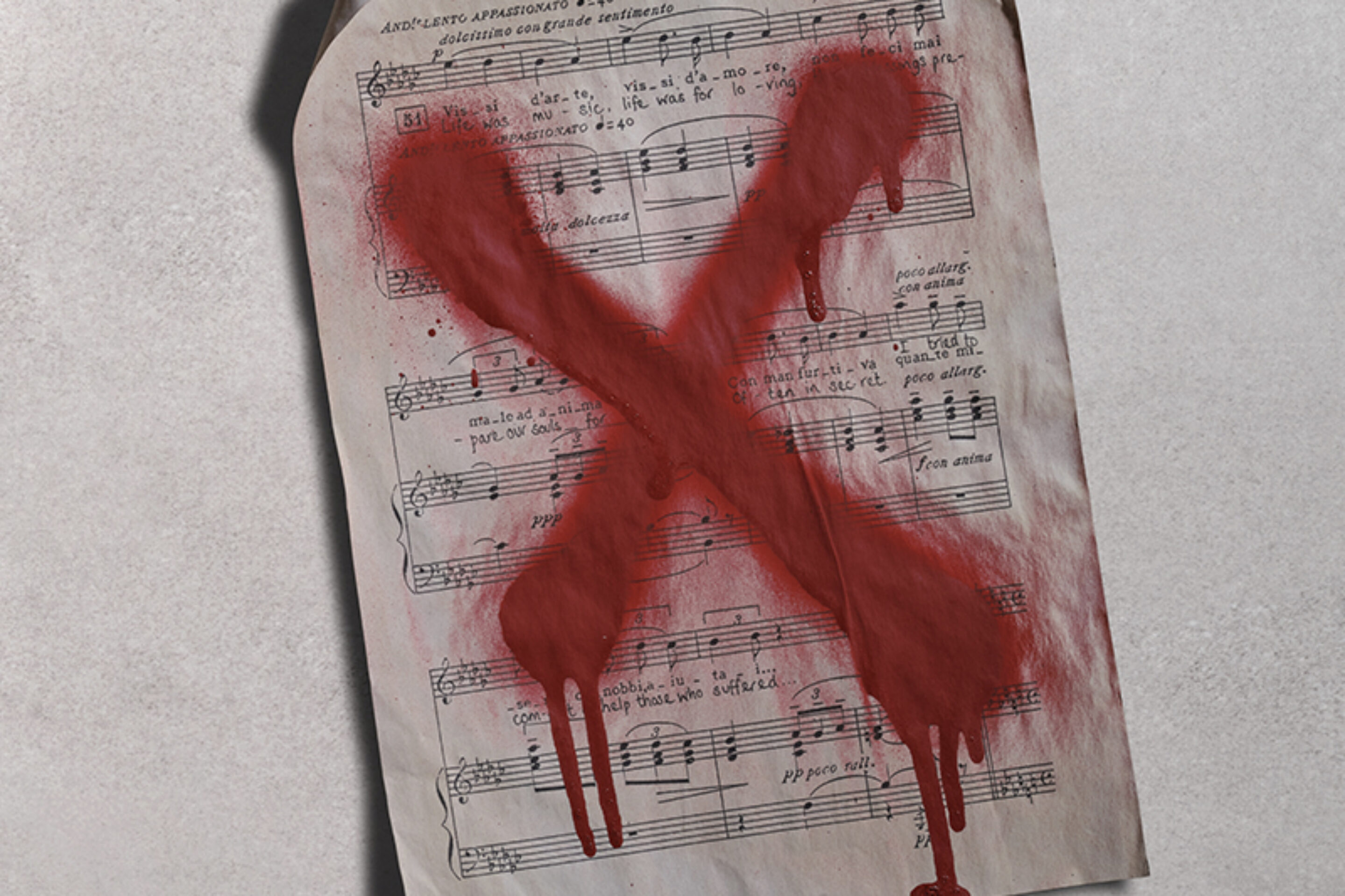 Three sheets of music lie on a grey surface, each marked with a large, red, painted X that appears to be dripping, suggesting rejection or censorship.